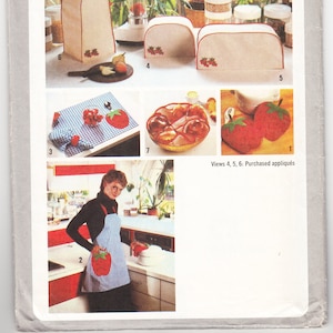 Op de afbeelding: Een Simplicity naaipatroon voor keukenaccessoires, met een rood-wit geruite schort met een aardbei-applicatie en verschillende apparaathoezen met aardbei-applicaties. Het patroonnummer is 9255.
