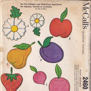 Op de afbeelding: Een vintage McCall's transferpatroon voor zes pottenhouders en bijpassende applicaties. Het patroon bevat een madeliefje, een appel, een peer, een pruim, een aardbei en een perzik. Het patroon is voor vilt of stof en heet "McCall's Multi-Blue 2460".