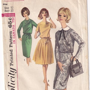 May include: A vintage sewing pattern for a dress with a collar and a skirt. The pattern is from Simplicity and is number 5613. The pattern is for a size 12 and a bust size of 32 inches.