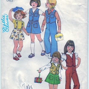 Op de afbeelding: Simplicity naaipatroon nummer 7321 voor kinderkleding. Het patroon bevat vier verschillende outfits: een blauwe denimjurk, een blauwe denimvest met broek, een rok met bloemenprint en een geel topje, en een groene rok met een bloemenvest. Het patroon is voor maat 2 kind.