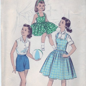 Puede incluir: Un patrón de costura vintage para dos vestidos de niña. El patrón es para la talla 10 y presenta un vestido de vichy verde con cuello blanco y un vestido de vichy azul con cuello blanco. El patrón se llama "Advance" y el número de patrón es 8660.