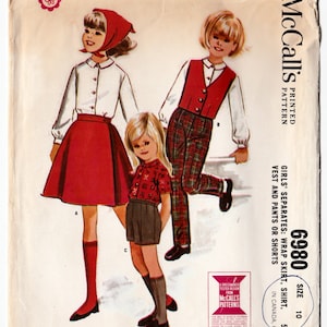 Peut inclure: Un patron de couture vintage pour des séparés de filles, comprenant une jupe portefeuille, une chemise, un gilet et un pantalon ou un short. Le patron est de McCall's et est de taille 10. L'image montre deux filles portant les différentes pièces du patron.
