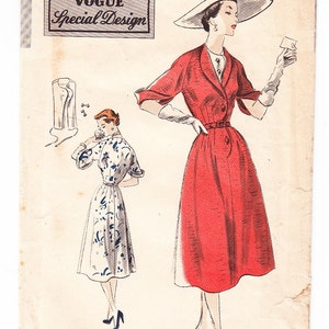 Pode incluir: Padrão de costura vintage Vogue para um vestido, tamanho 14, com uma medida de busto de 81 cm e uma medida de quadril de 89 cm. O padrão apresenta um vestido vermelho com gola branca e cinto branco, e um vestido branco com padrão floral azul. O padrão é de 1951.