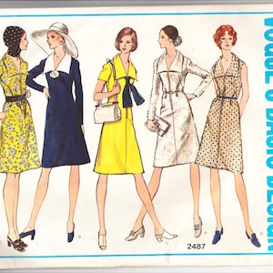 Op de afbeelding: Vintage Vogue Basic Design naaipatroon met vijf geïllustreerde jurken. De jurken omvatten een gele bloemenprint, een marineblauwe jurk met een witte kraag en een gele jurk met een zwarte strik. Het patroonnummer is 2487.