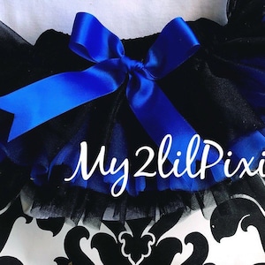 May include: Black tulle tutu with a royal blue satin bow and the text "My 2 Lil Pixies" on the front.