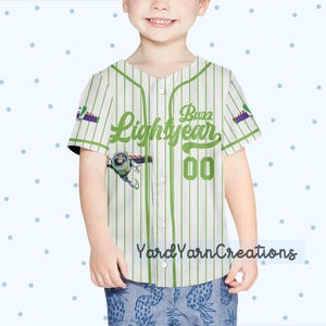 K&ouml;nnte beinhalten: Ein wei&szlig;-gr&uuml;n gestreiftes Baseball-Trikot mit dem Text "Buzz Lightyear" und der Nummer "00" in Gr&uuml;n. Das Trikot hat ein Cartoon-Bild von Buzz Lightyear und den Text "Yard Yarn Creations" unten.