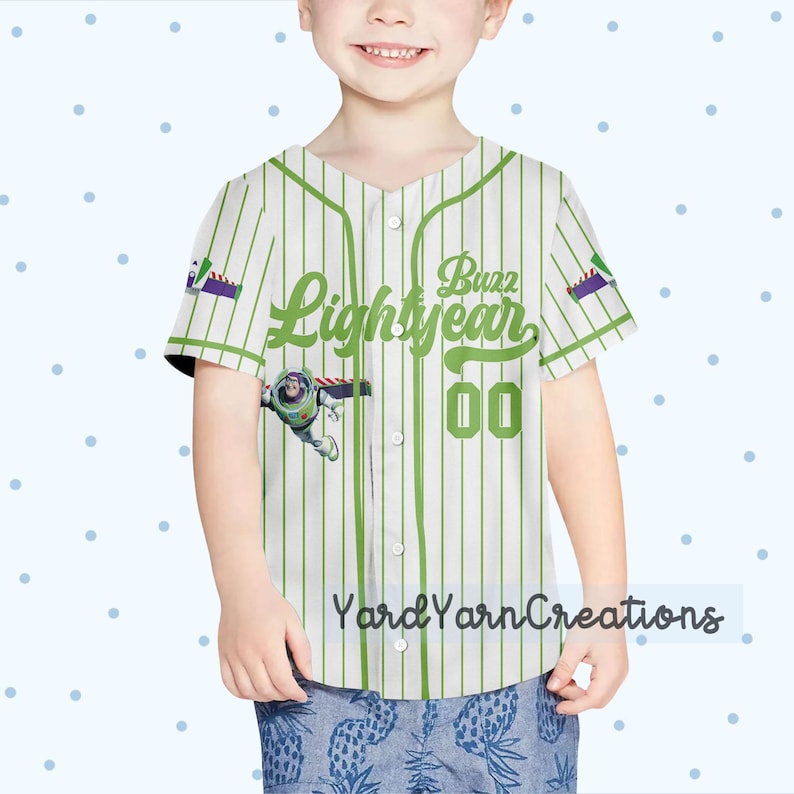 K&ouml;nnte beinhalten: Ein wei&szlig;-gr&uuml;n gestreiftes Baseball-Trikot mit dem Text "Buzz Lightyear" und der Nummer "00" in Gr&uuml;n. Das Trikot hat ein Cartoon-Bild von Buzz Lightyear und den Text "Yard Yarn Creations" unten.