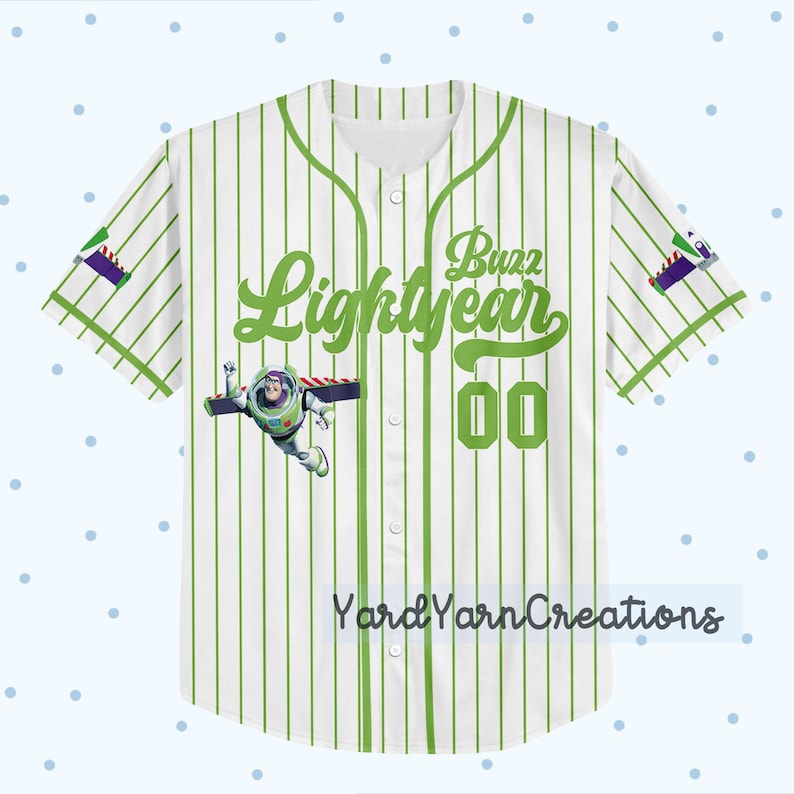 K&ouml;nnte beinhalten: Wei&szlig;es Baseball-Trikot mit gr&uuml;nen Nadelstreifen, mit "Buzz Lightyear" in gr&uuml;ner Schrift. Enth&auml;lt eine Grafik von Buzz Lightyear und die Nummer "00". Die &Auml;rmel haben ein lila und gr&uuml;nes Design. Der Text "Yard Yarn Creations" steht unten.