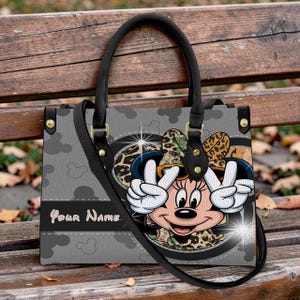 Puede incluir: Una taza de cer&aacute;mica blanca con un asa negra y el texto "But First, Coffee" en negro y negrita. La taza est&aacute; sobre una superficie de madera.