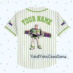 K&ouml;nnte beinhalten: Wei&szlig;es Baseball-Trikot mit gr&uuml;nen Nadelstreifen und Akzenten. Verf&uuml;gt &uuml;ber eine Buzz Lightyear-Grafik und den Text "YOUR NAME" in Gr&uuml;n. Das Trikot hat auch den Text "YardYarnCreations" unten.