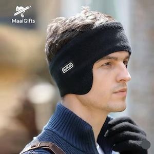 May include: A black ear warmer with the text "COLORJOY" on the side. The ear warmer is made of a knitted material and covers the ears and forehead. The person in the image is wearing a blue sweater and black gloves.