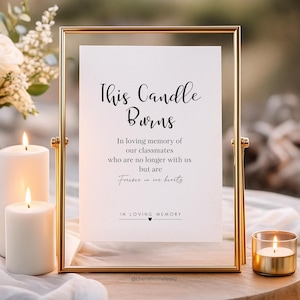 Op de afbeelding: Een goudkleurig omlijst bord met de tekst "This Candle Burns" en een herdenkingsboodschap. Het bord is omgeven door brandende kaarsen, wat een warme en troostende sfeer creëert. De tekst luidt "In loving memory of our classmates who are no longer with us but are Forever in our hearts."