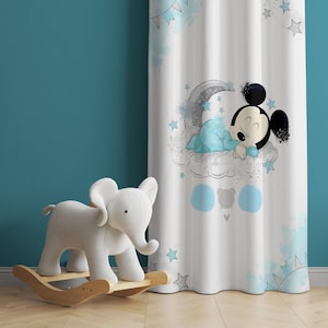 May include: A white curtain with a blue and gray watercolor design featuring a sleeping Mickey Mouse on a cloud with stars. The curtain is hung in a room with a light blue wall and a rocking elephant toy.
