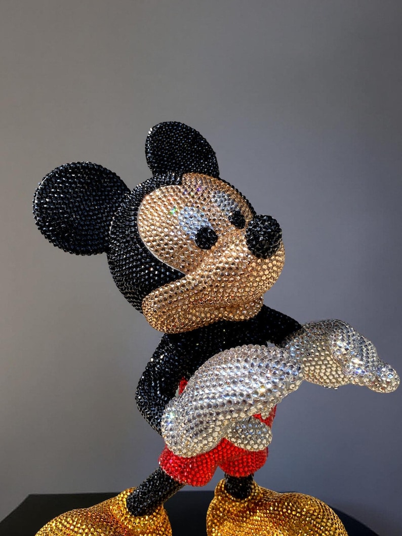 Detailed close-up of the front of the "MICKEY LOVE" Pop Art statue, focusing on the torso, hands, and feet. The image highlights the intricate hand-applied black, gold, and red glass crystals covering the figurine. The silver rhinestone-encrusted gloves and the shimmering red shorts provide a striking contrast to the gold shoes. This exclusive, signed collectible sculpture by artist NOISYX showcases a luxurious, bling aesthetic with impeccable craftsmanship.