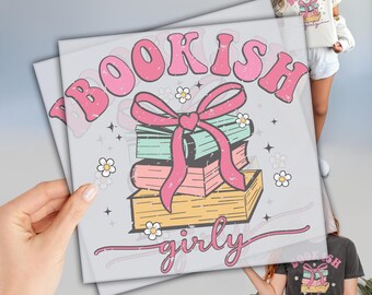 May include: A light gray graphic print featuring the words "BOOKISH girly" in pink, with a stack of books tied with a pink bow. The books are in shades of yellow, pink, and teal, with small white flowers and stars scattered around the design.