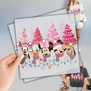 May include: A light gray print featuring Disney characters in Christmas attire. The characters include Mickey Mouse, Minnie Mouse, Donald Duck, Goofy, and Pluto, all wearing Santa hats and scarves. Pink Christmas trees and string lights are in the background.