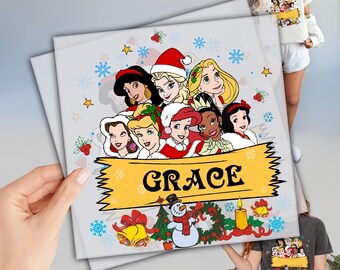 May include: A light gray square print featuring a group of cartoon princesses in Santa hats and winter attire. The word "GRACE" is displayed on a yellow banner. Snowflakes and Christmas decorations surround the princesses.