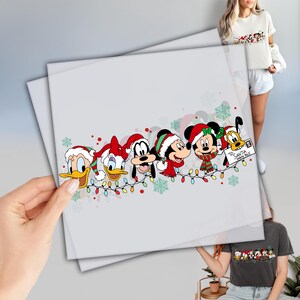 May include: A Christmas-themed illustration featuring Mickey Mouse, Minnie Mouse, Donald Duck, Goofy, and Pluto wearing Santa hats and surrounded by colorful lights. The text "To Santa, With Love" is on a letter held by Pluto.