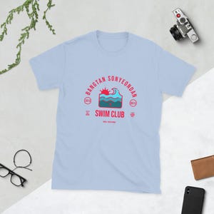Puede incluir: Una taza de cerámica blanca con asa negra y el texto "But First, Coffee" en estilo manuscrito. La taza está sobre una superficie blanca. Ideal para bebidas calientes.