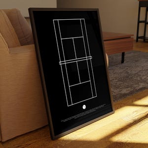 Peut inclure: Une impression minimaliste en noir et blanc d'un court de tennis avec une balle de tennis blanche au centre. L'impression est encadrée dans un cadre noir.