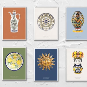 May include: Six framed art prints featuring Italian pottery designs. The prints showcase a decorative olive oil cruet, a ceramic plate, a pineapple-shaped vase, a plate with lemons, a sun face, and a decorative head vase.
