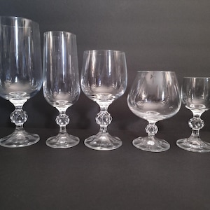 May include: Five clear glass goblets of varying sizes and shapes, all with a diamond-shaped base.