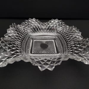 May include: A clear glass square dish with a diamond pattern and a scalloped edge.