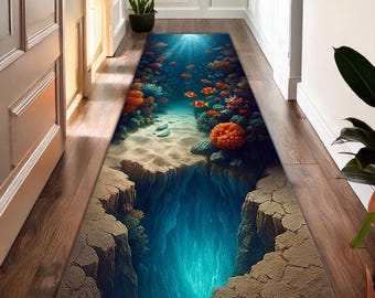 Könnte beinhalten: Ein rechteckiger Teppich mit einem Unterwasser-Szenen-Design. Der Teppich zeigt einen tiefblauen Abgrund, einen sandigen Meeresboden, Korallen und orangefarbene Fische. Das Design erzeugt einen 3D-Effekt.