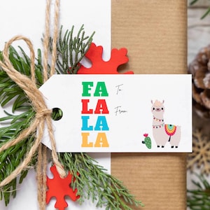 Può includere: Un'etichetta regalo bianca con le parole "FA LA LA LA" in lettere colorate, legata con spago e verde. L'etichetta presenta un'illustrazione di lama con un cactus. È visibile un elemento decorativo rosso.