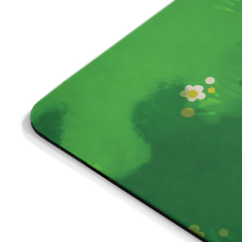 Puede incluir: Un tapete para rat&oacute;n verde y blanco con un sutil efecto acuarela. El tapete para rat&oacute;n presenta un dise&ntilde;o de flores blancas con centros amarillos sobre un fondo verde.