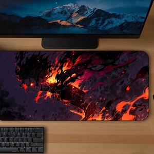 May include: A rectangular mousepad featuring a fiery, abstract design in shades of red, orange, and black. The mousepad is placed on a wooden desk, alongside a black keyboard, mouse, and two potted plants. A computer monitor is visible in the background.