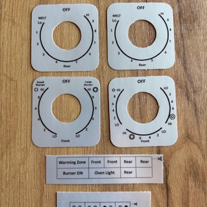 May include: A set of four square white stove control knob overlays with black text and circular cutouts. The labels include OFF, MELT, HI, LO, Rear, Front, Small Burner, and Large Burner. Additional rectangular strips feature text labels and burner icons.