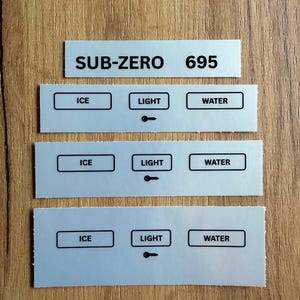 May include: Four rectangular silver stickers with black text. The top sticker reads SUB-ZERO 695. The three identical stickers below feature boxes labeled ICE, LIGHT, and WATER, with a small key icon beneath the word LIGHT on each sticker.