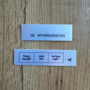 May include: Two rectangular white adhesive labels with black text. The top label displays GE #PVM9195SF1SS. The bottom label features three distinct sections labelled Timer On/Off, Vent Fan, and Surface Light, with a scissor icon indicating a cut line.