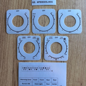 Peut inclure: Un ensemble de cinq superpositions carrées gris clair pour boutons de commande de cuisinière avec marquages et chiffres noirs, incluant une étiquette GE. #PB930SJ4SS et une feuille rectangulaire avec des schémas de brûleurs et des étiquettes.