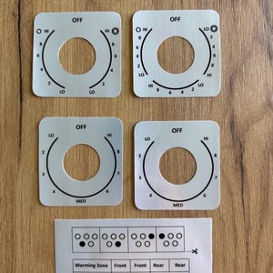 May include: Four square white stove knob overlays with black printed markings for heat settings including OFF, LO, HI, and numbers 2 through 8. Includes a rectangular label with Samsung #NE59J7630, #NE59M7630 and a guide for burner indicators and zones.