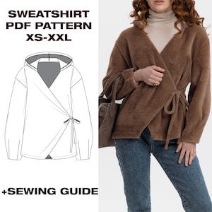 Può includere: Una felpa marrone avvolgente con cappuccio e chiusura con lacci. L'immagine presenta anche un disegno a tratto del modello della felpa, con il testo "SWEATSHIRT PDF PATTERN XS-XXL" e "+SEWING GUIDE". La modella indossa jeans blu.