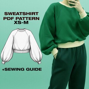 Peut inclure: Un patron de couture numérique pour sweat-shirt avec un dessin technique montrant un col rond, des manches raglan et des poignets côtelés. Le texte indique SWEATSHIRT PDF PATTERN XS-M +SEWING GUIDE. Un sweat-shirt vert à bordure crème est visible.
