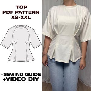 Pode incluir: Uma blusa branca de manga curta com decote redondo e pregas verticais na cintura. A imagem inclui um desenho técnico da blusa, o texto TOP PDF PATTERN XS-XXL, +SEWING GUIDE e +VIDEO DIY, juntamente com uma foto da blusa vestida.