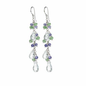 May include: A pair of dangling earrings with a silver chain and hook. The earrings feature clear, teardrop-shaped crystals and clusters of small, round green and purple beads. The design is elegant and suitable for special occasions.