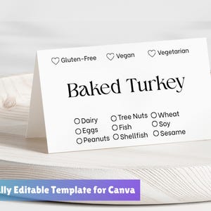 Könnte beinhalten: Eine weiße Karte mit den Worten "Baked Turkey" in fetter Schrift. Die Karte listet häufige Allergene und Ernährungsvorlieben wie glutenfrei, vegan und vegetarisch auf. Die Karte liegt auf einem Holztablett.