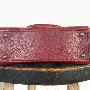 May include: A red leather handbag with a textured crocodile pattern. The bag has silver hardware and a top handle.