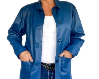 May include: A blue leather jacket with a button-up front and two pockets. The jacket is worn over a white t-shirt and blue jeans.
