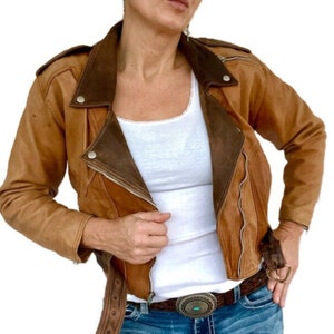 Veste en cuir effet vieilli style années 80, veste courte asymétrique, épaulettes cloutées. S