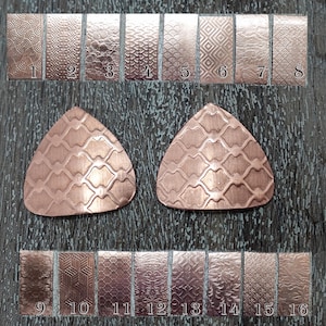 May include: Copper metal sheets with various textured patterns, numbered 1 to 16. Two triangular copper pieces with a geometric design are also shown. The textures include swirls, waves, and geometric shapes.