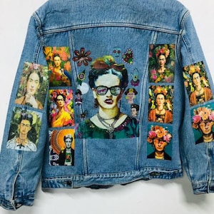 Puede incluir: Una chaqueta vaquera azul con parches coloridos que muestran imágenes de Frida Kahlo. Los parches están dispuestos en una cuadrícula en la parte posterior de la chaqueta.