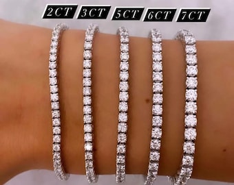 May include: Five diamond tennis bracelets in different sizes, 2 carat, 3 carat, 5 carat, 6 carat, and 7 carat. The bracelets are on a woman's wrist.