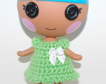 May include: A green crocheted dress with a white bow on a doll with blue hair and large black eyes.