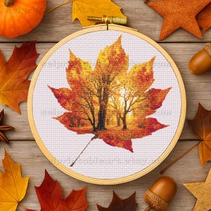 Romantic autumn forest landscape cross stitch inside a maple leaf design - Golden fall leaf embroidery pattern featuring a glowing woodland scene - Nature-inspired autumn decor – maple leaf cross stitch with forest sunlight - Rustic woodland fall embroidery, perfect for cozy seasonal wall art - Detailed maple leaf cross stitch pattern with a warm, romantic autumn theme