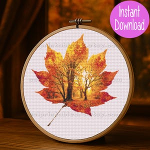 Romantic autumn forest landscape cross stitch inside a maple leaf design - Golden fall leaf embroidery pattern featuring a glowing woodland scene - Nature-inspired autumn decor – maple leaf cross stitch with forest sunlight - Rustic woodland fall embroidery, perfect for cozy seasonal wall art - Detailed maple leaf cross stitch pattern with a warm, romantic autumn theme